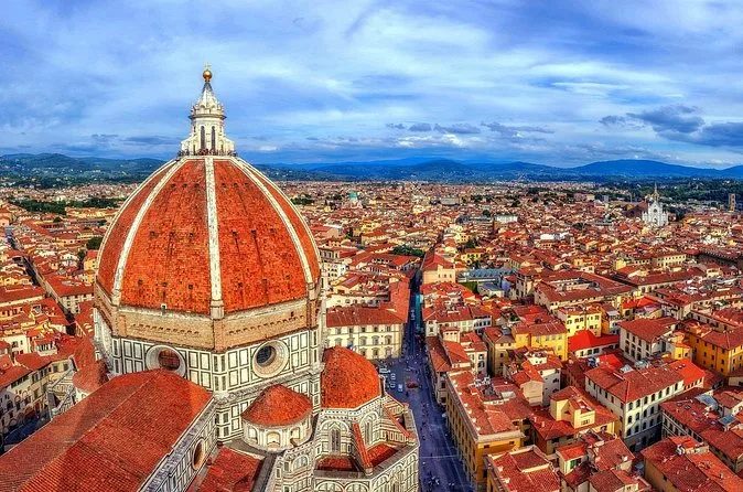 Aerial view of the red-tiled dome of Florence Cathedral and its white marble lantern above the city roofs